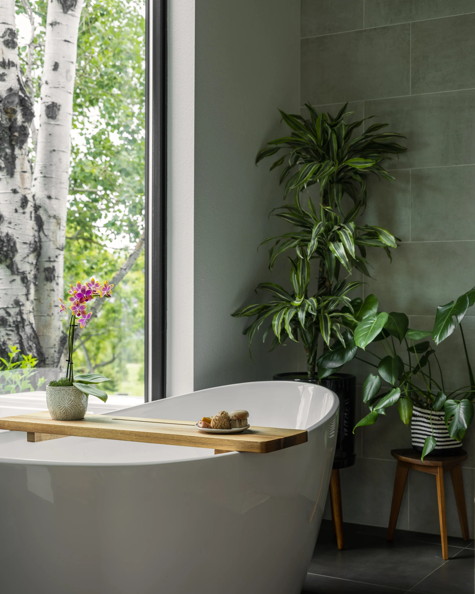 Freestanding soaking tub framed by an aspen-grove view — interior design photography Bozeman Montana, Living Places Design Studio